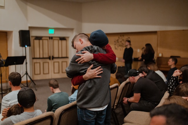 Two people hugging during a support group session.