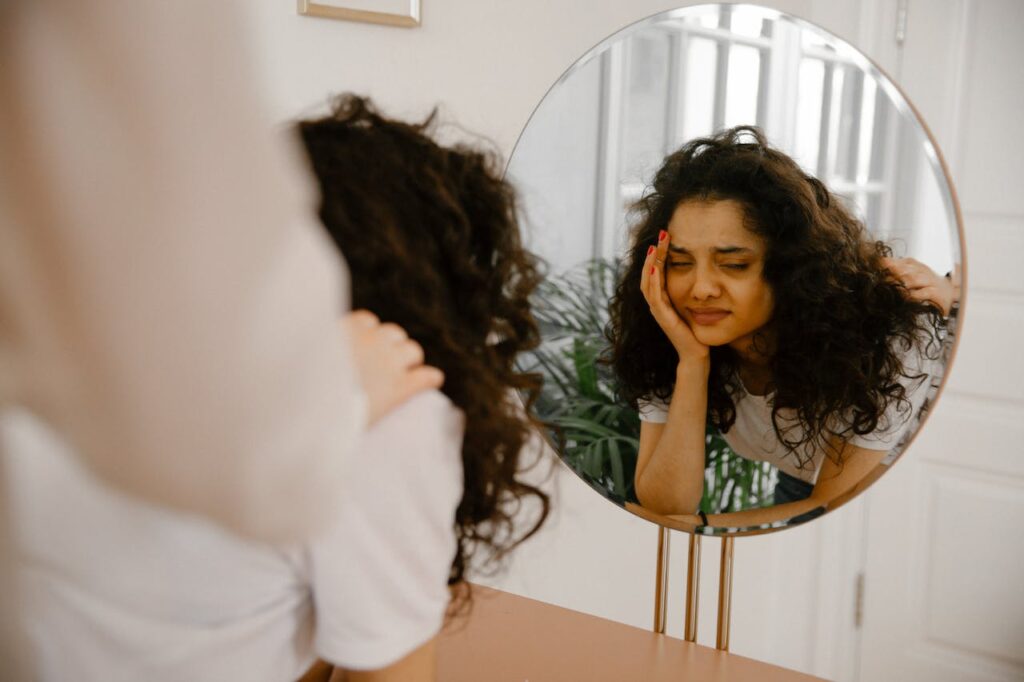 A woman closed her eyes in disgust after seeing herself in the mirror, illustrating the
consequences of trauma on self-esteem and identity in adulthood.